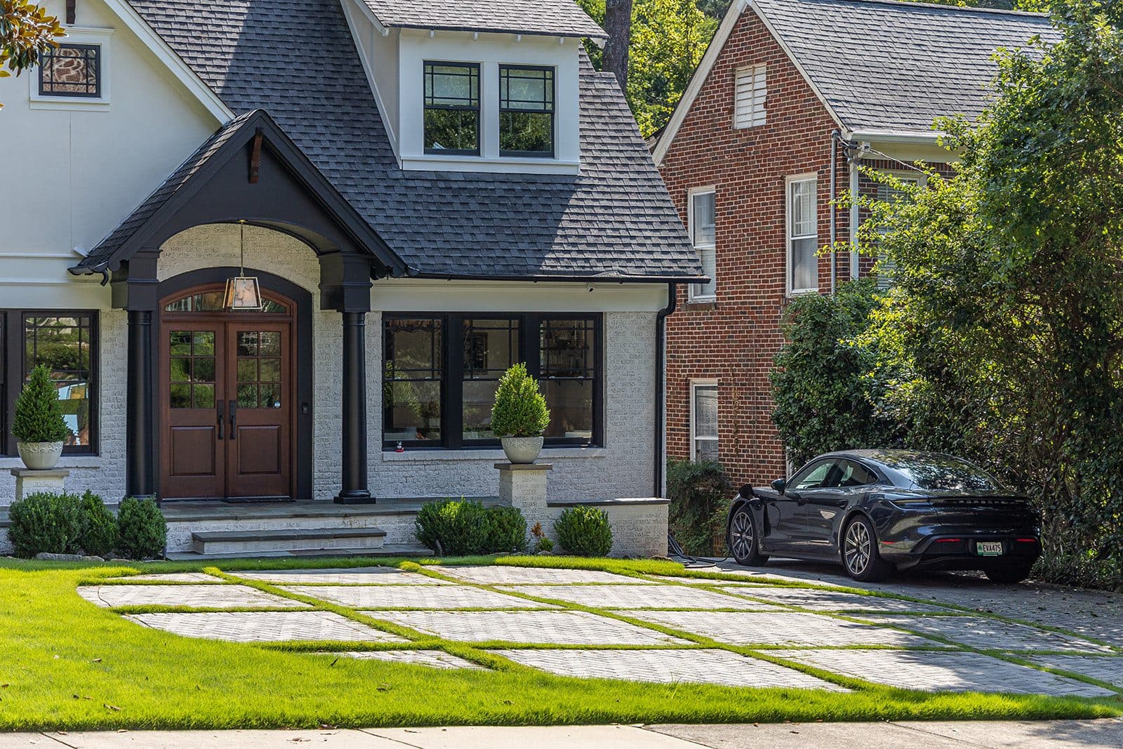 A custom paver motor court with planted grass joints leading to the arched entry of an Atlanta estate, built by Earthcore Group