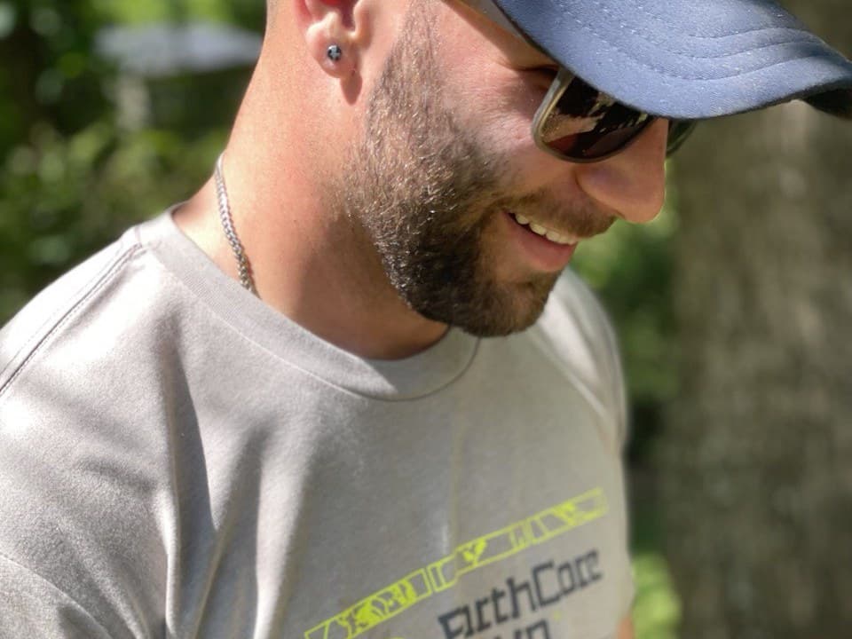 Jordan, Earthcore's project lead, smiling on a site visit in the yellow-lettered Earthcore shirt